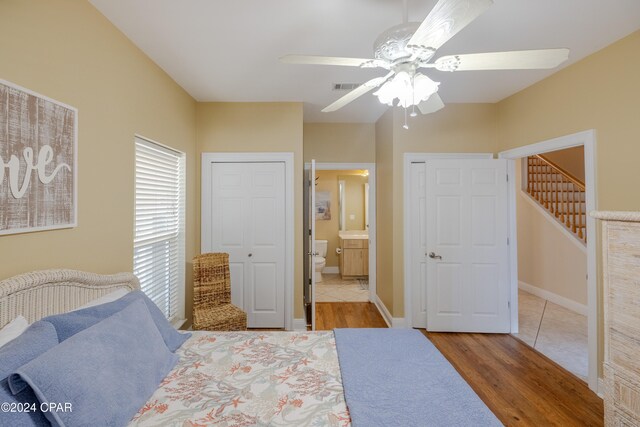 bedroom featuring ceiling fan, wood-type flooring, and ensuite bath