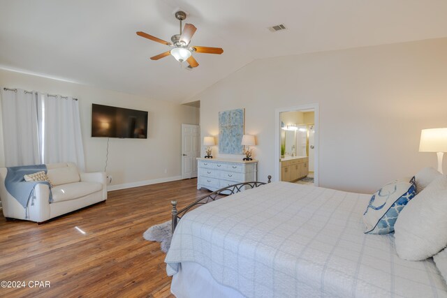 bedroom featuring wood-type flooring, ensuite bath, ceiling fan, and lofted ceiling