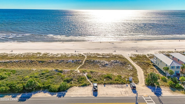 birds eye view of property with a water view and a beach view