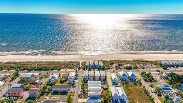 birds eye view of property with a water view and a beach view