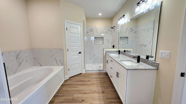 bathroom with hardwood / wood-style flooring, vanity, and shower with separate bathtub