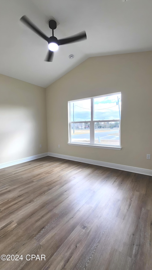 empty room featuring ceiling fan, wood-type flooring, and vaulted ceiling