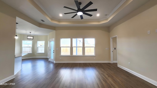 spare room with ceiling fan with notable chandelier, dark hardwood / wood-style floors, a raised ceiling, and ornamental molding