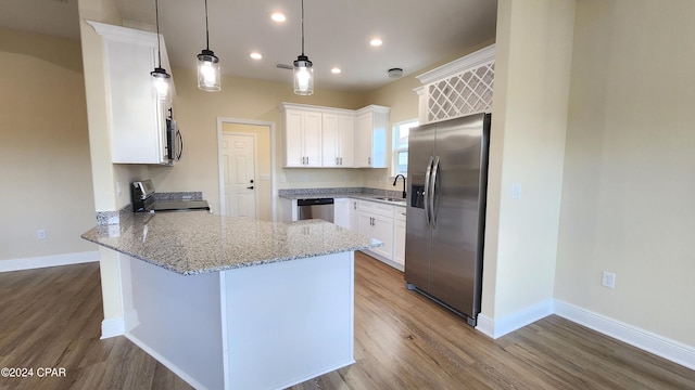 kitchen with sink, hanging light fixtures, stainless steel appliances, kitchen peninsula, and white cabinets