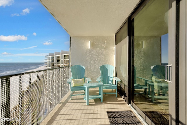 balcony with a water view and a view of the beach