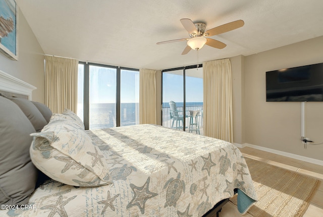 bedroom featuring access to exterior, ceiling fan, floor to ceiling windows, tile patterned floors, and a textured ceiling