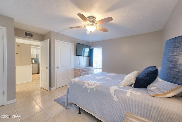 tiled bedroom featuring stainless steel fridge, ceiling fan, and a textured ceiling