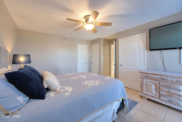 tiled bedroom featuring a textured ceiling and ceiling fan