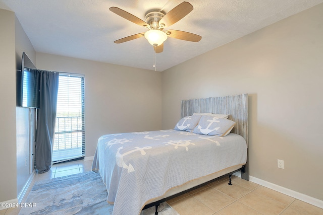 tiled bedroom featuring a textured ceiling and ceiling fan