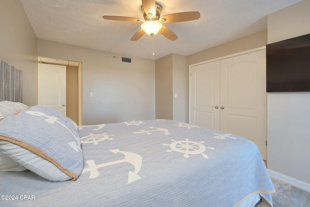 bedroom with carpet, a textured ceiling, a closet, and ceiling fan