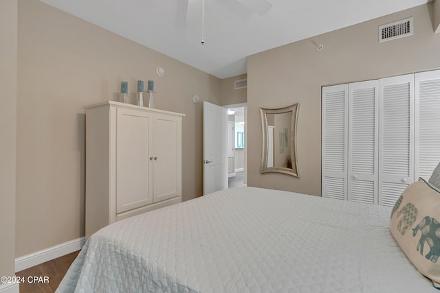 bedroom with dark hardwood / wood-style floors, a closet, and ceiling fan