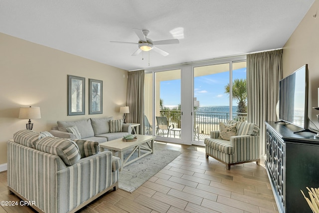 living room with ceiling fan, a healthy amount of sunlight, floor to ceiling windows, and a textured ceiling