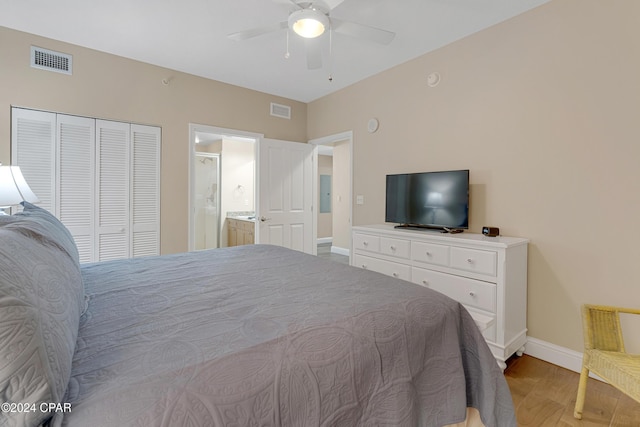 bedroom with light hardwood / wood-style floors, a closet, ceiling fan, and ensuite bathroom