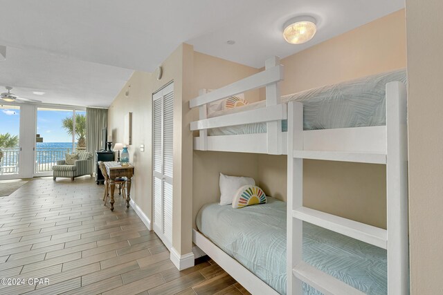 bedroom with hardwood / wood-style floors, access to exterior, and a closet