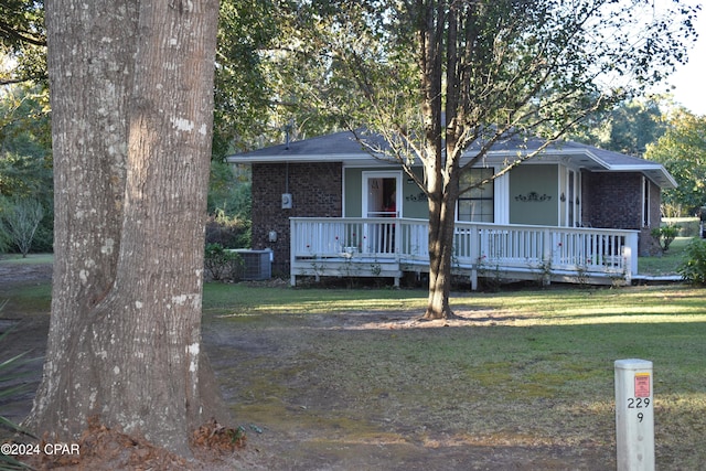 view of front of house featuring a front yard and central AC