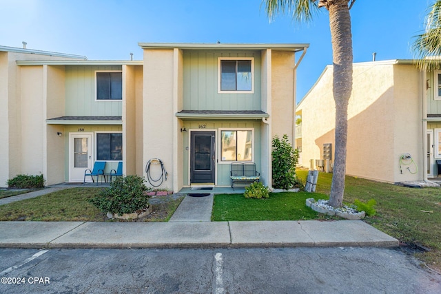 townhome / multi-family property featuring a front yard