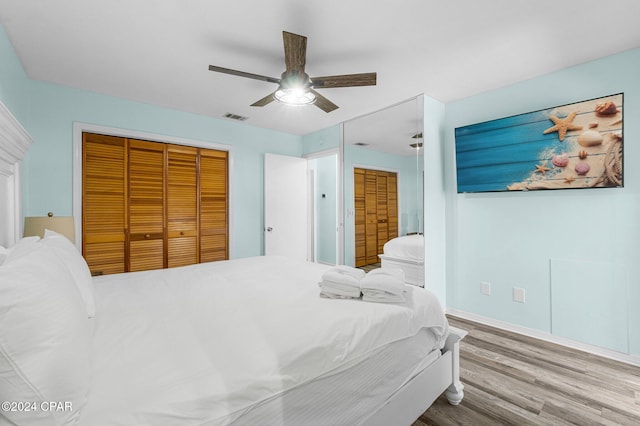 bedroom featuring hardwood / wood-style floors, ceiling fan, and a closet