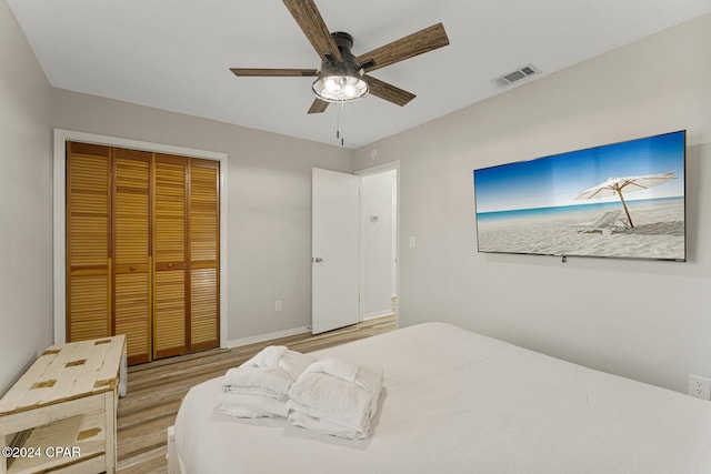 bedroom with ceiling fan, wood-type flooring, and a closet