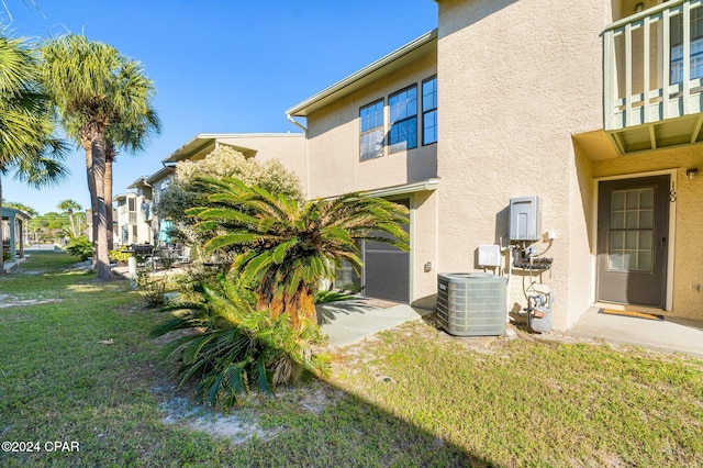 view of side of home featuring a lawn and central AC unit