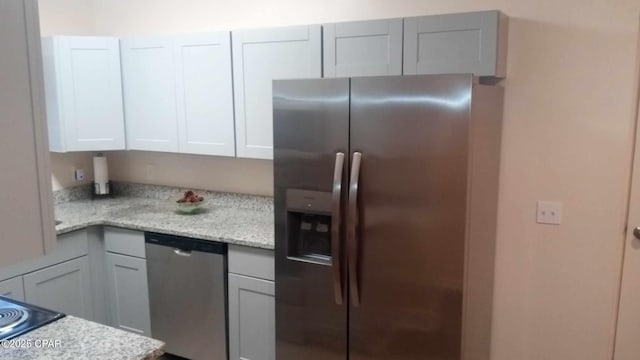 kitchen featuring stainless steel appliances and light stone countertops