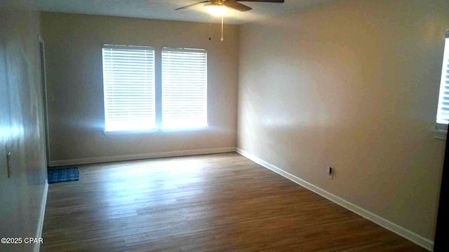 spare room featuring dark hardwood / wood-style flooring and ceiling fan