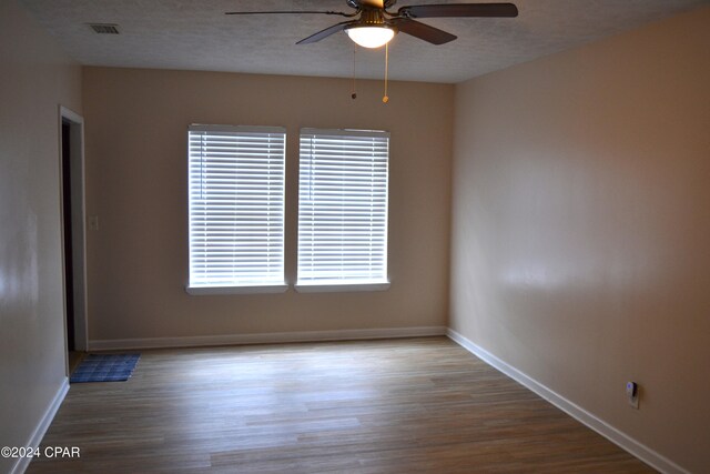 848 Helen Ave, Panama City, FL 32401 - empty room with ceiling fan, wood finished floors, baseboards, and a textured ceiling