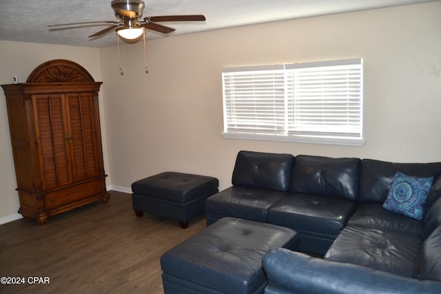 living room featuring dark wood-type flooring and ceiling fan