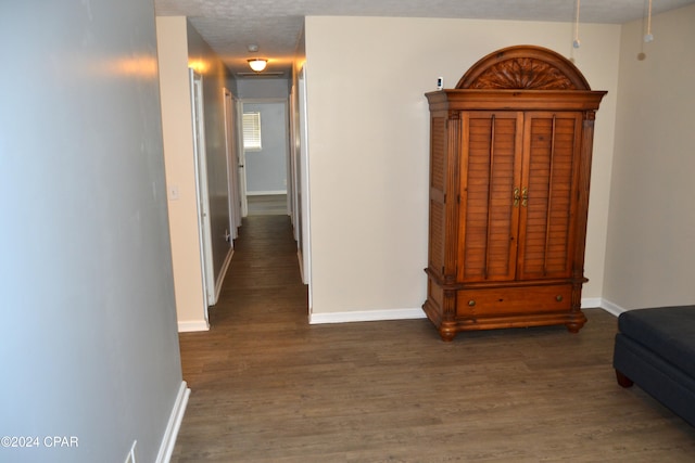 hall featuring a textured ceiling and dark hardwood / wood-style flooring