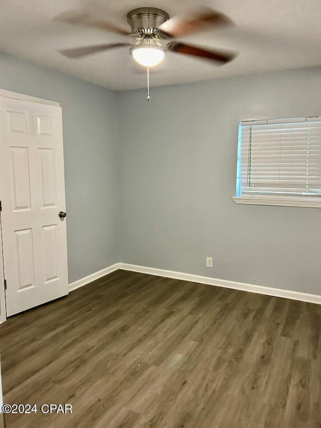 empty room with ceiling fan and dark hardwood / wood-style floors