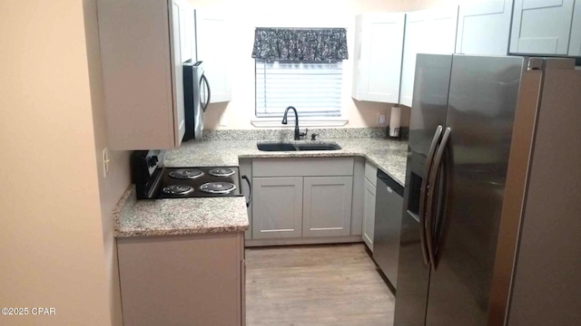 848 Helen Ave, Panama City, FL 32401 - kitchen featuring a sink, appliances with stainless steel finishes, light wood-style floors, and light stone counters