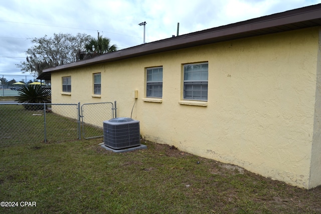 view of side of property featuring a yard and central air condition unit