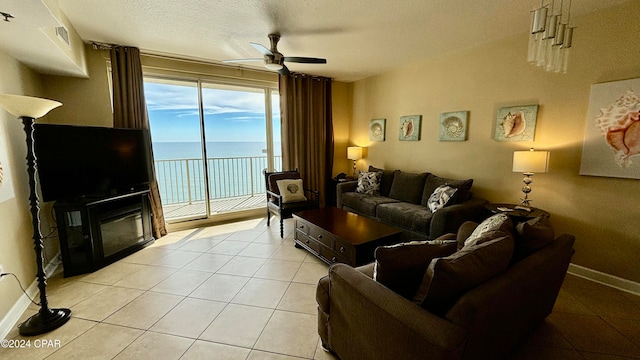 tiled living room with ceiling fan and a textured ceiling