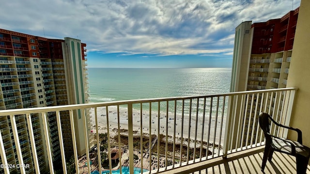 balcony with a water view and a beach view