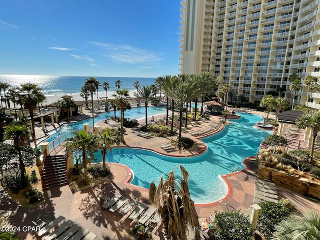 view of swimming pool with a view of the beach and a water view