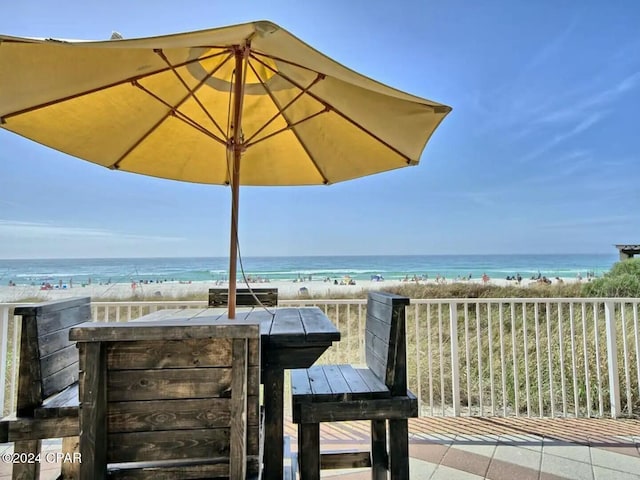 view of patio featuring a view of the beach, an outdoor bar, and a water view