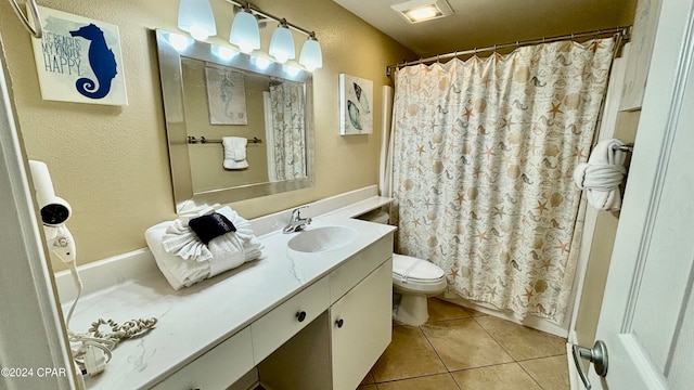 bathroom featuring toilet, vanity, tile patterned floors, and curtained shower