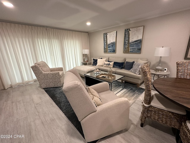 living room featuring crown molding and light hardwood / wood-style flooring