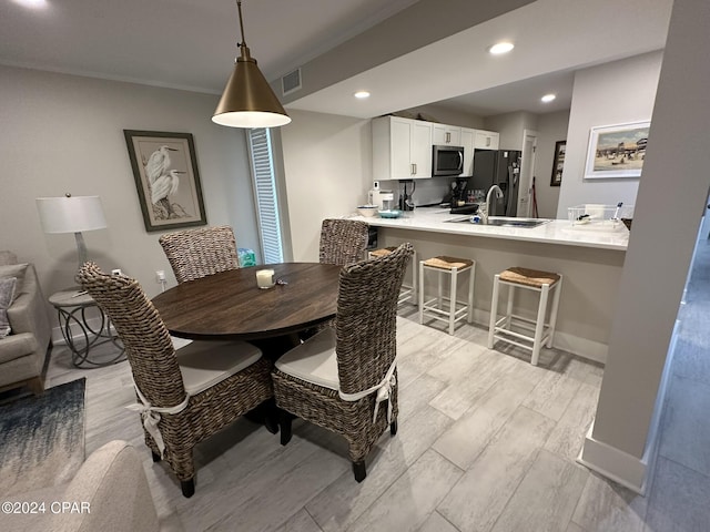 dining space featuring ornamental molding and sink