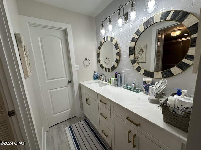 bathroom featuring hardwood / wood-style flooring, decorative backsplash, and vanity