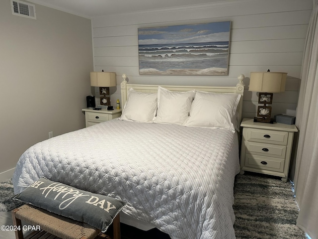 bedroom featuring wooden walls and crown molding