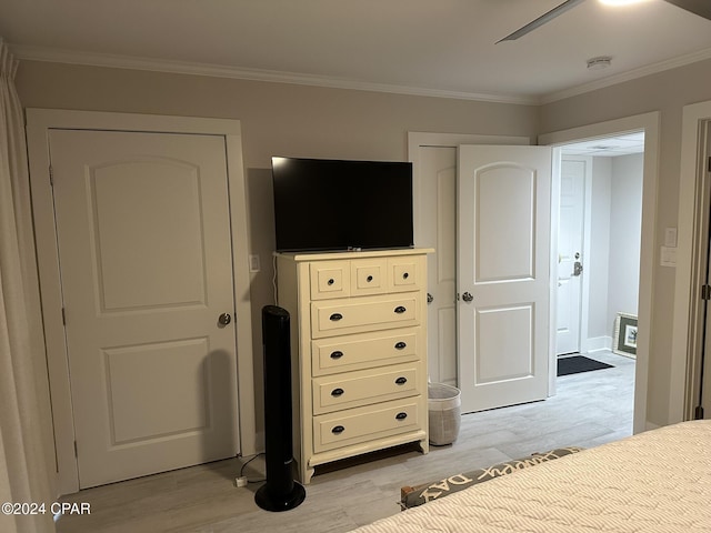 bedroom with crown molding, ceiling fan, and light hardwood / wood-style flooring