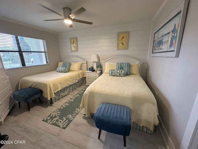 bedroom featuring ornamental molding, wood walls, and ceiling fan