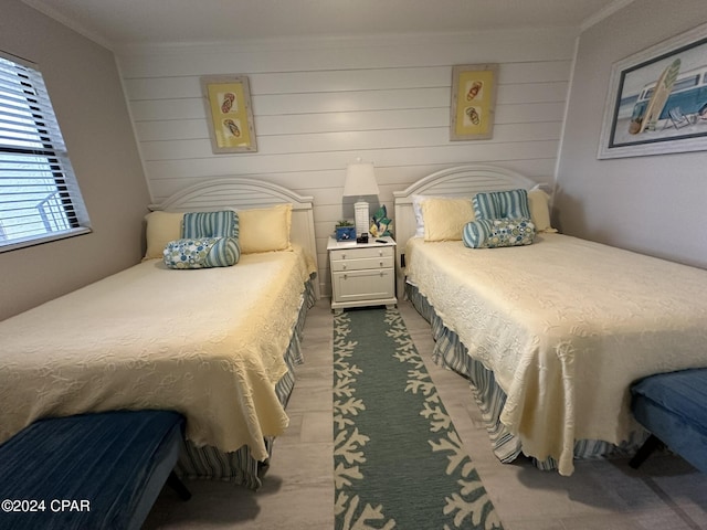 bedroom with wood walls and ornamental molding