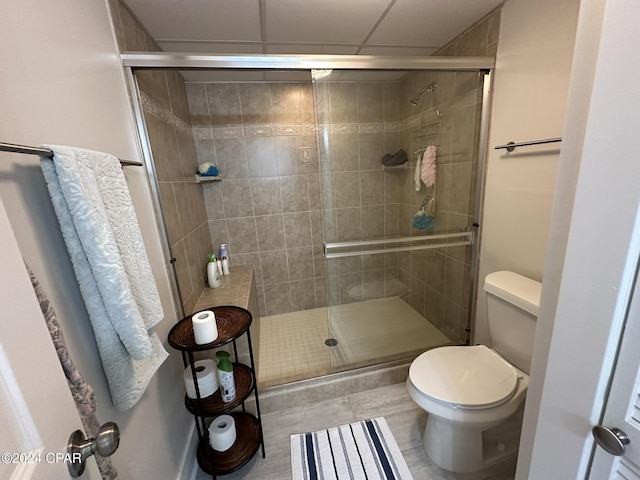 bathroom with toilet, an enclosed shower, and tile patterned floors