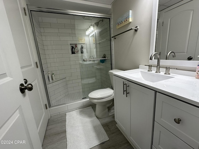 bathroom with a shower with shower door, vanity, and toilet