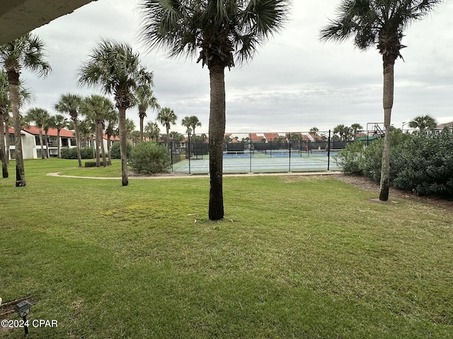 view of home's community with tennis court and a lawn