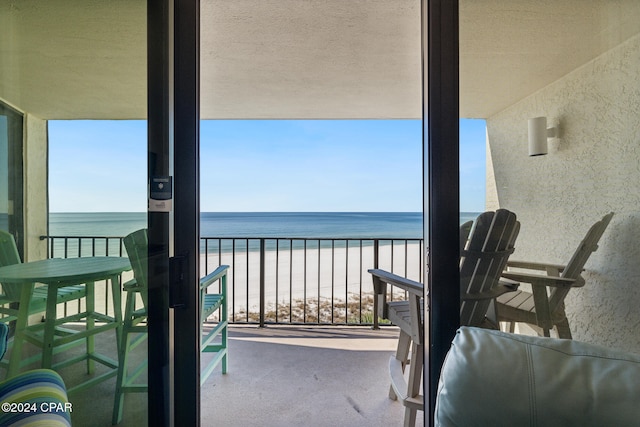 balcony featuring a water view and a view of the beach