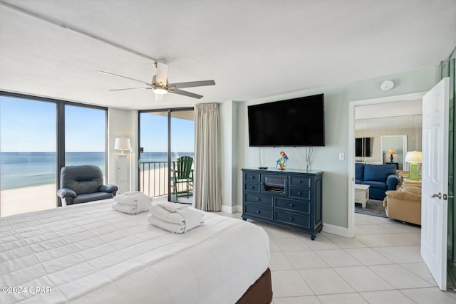 tiled bedroom featuring ceiling fan, floor to ceiling windows, and access to exterior