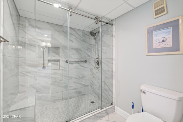 bathroom with tile patterned floors, toilet, and an enclosed shower