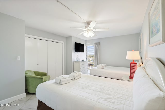 tiled bedroom with ceiling fan and a closet